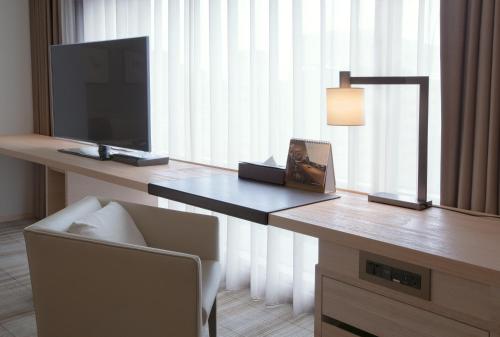 a room with a desk with a television and a chair at Hotel COZZI Minsheng Taipei in Taipei
