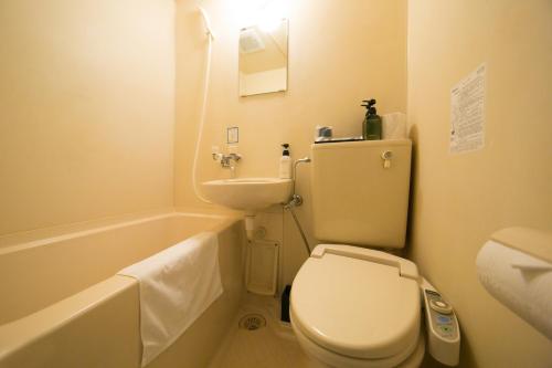 ein Badezimmer mit einem WC, einem Waschbecken und einer Badewanne in der Unterkunft HOTEL 910 in Ōita