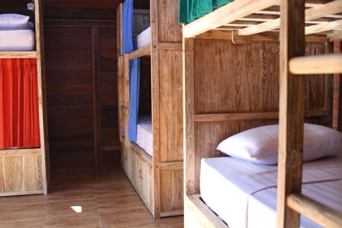 two bunk beds in a room with wooden walls at The Tipsy Gypsy Hostel in Canggu