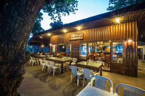Long Beach Lodge, Chaweng Beach, Koh Samui في شاطئ تشاوينغ: مطعم فيه طاولات وكراسي امام مبنى