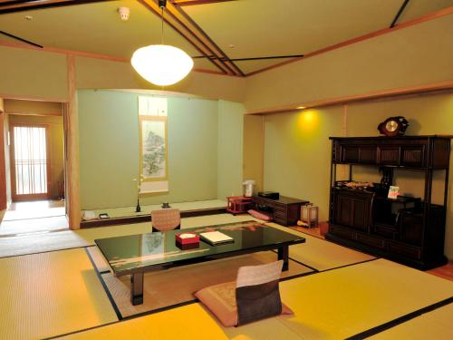 a living room with a glass table and chairs at Nisshokan Bettei Koyotei in Nagasaki