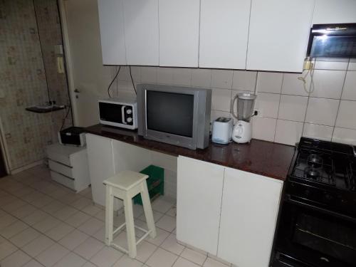 a kitchen with a microwave and a tv on a counter at Casa de Familia - Solo Para Mujeres *Woman ONLY* in Buenos Aires