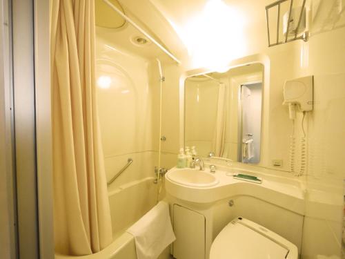 a bathroom with a toilet and a sink and a shower at Hotel Route-Inn Anan in Anan