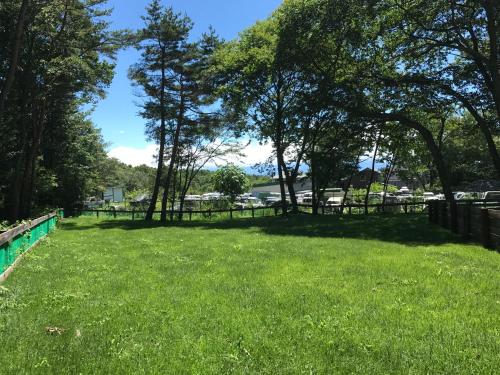 a large yard with trees and a fence at DogrunCafe & Resorts JENNIE West-Karuizawa in Miyota