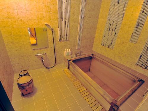 a bathroom with a tub and a toilet and a shower at Nisshokan Bettei Koyotei in Nagasaki