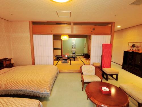 a bedroom with two beds and a living room at Nisshokan Bettei Koyotei in Nagasaki