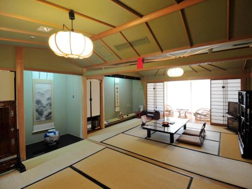 sala de estar con sofá y mesa en Nisshokan Bettei Koyotei, en Nagasaki