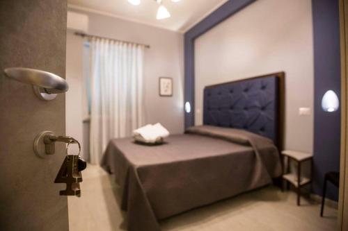 a bedroom with a bed with a blue head board at BebNonnaMaria1928 in Salerno