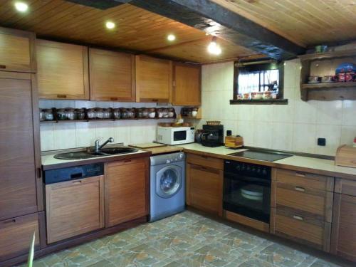 een keuken met een wasmachine en een wastafel bij Къща за гости Ножери in Tryavna