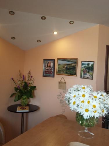 a room with a vase of flowers on a table at Šolena in Alytus