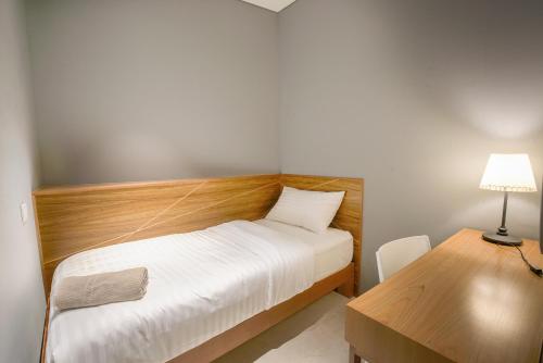 a bedroom with a bed and a desk with a lamp at The Bed KLCC in Kuala Lumpur