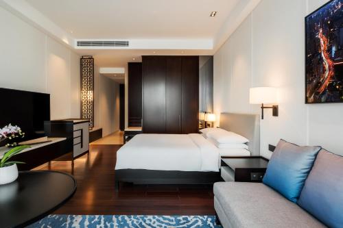 حياة ريجنسي شنغهاي غلوبال هاربور في شانغهاي: غرفة فندق بها سرير وأريكة