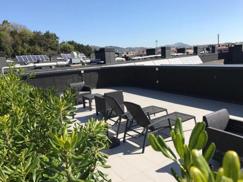 a group of chairs sitting on top of a roof at Talo Urban Rooms in Donostia-San Sebastián
