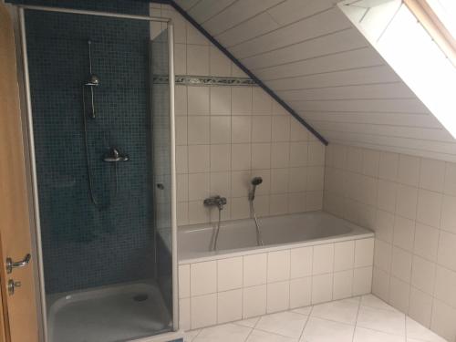 La salle de bains est pourvue d'une douche et d'une baignoire. dans l'établissement Eifelferienhaus Pruem, à Steinmehlen