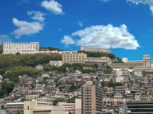 a view of a city with buildings on a hill at Nagasaki Nisshokan in Nagasaki