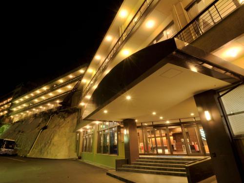 a building with lights on the side of it at night at Nagasaki Nisshokan in Nagasaki