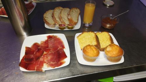 three plates of food on a table with muffins and fruit at Hotel rural L'Anceo in Cibuyo