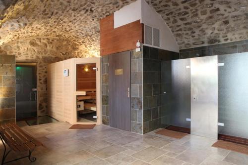 a room with a bathroom with a bench and a table at Domaine Saint-Roch Hotel Spa in Salzuit