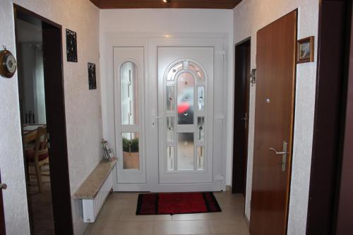 a hallway with a white door and a red rug at Ferienhaus am Emspark in Leer