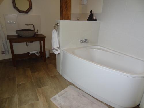 a bathroom with a white tub and a wooden floor at Marina Chic in Hasselberg