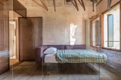 Schlafzimmer mit einem Bett und einer Glastür in der Unterkunft La Canonica in Asolo