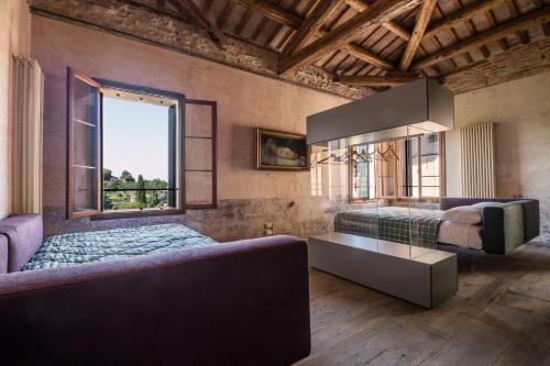 1 dormitorio con cama, sofá y ventana en La Canonica, en Asolo