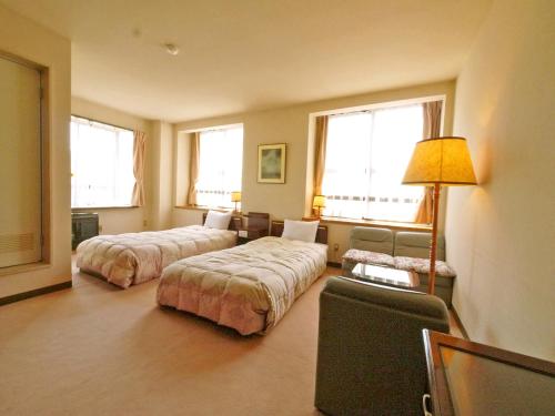 a hotel room with two beds and a lamp at Okunikko Park Lodge Miyama in Nikko