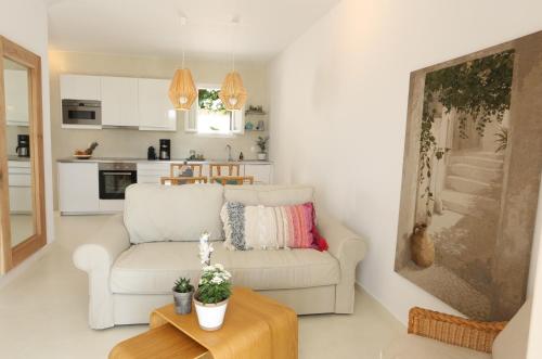 uma sala de estar com um sofá e uma mesa em Seafront Calista Beach House With Garden em Glyfada