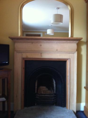 a fireplace with a mirror on top of it at Bankfoot Inn in Bankfoot