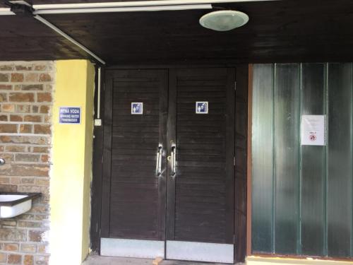 a wooden door in a building with signs on it at Camping Intercamp Tatranec in Vysoke Tatry - Tatranska Lomnica.