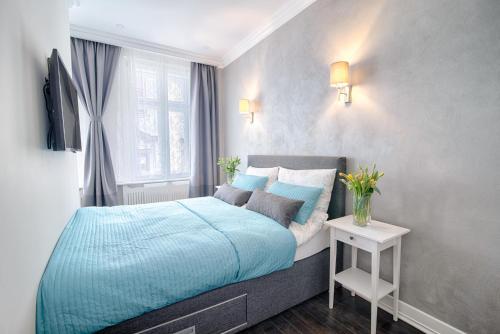 a bedroom with a blue bed and a window at Sweet 16 Studio in Ljubljana