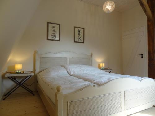 a bedroom with a white bed and two end tables at Marina Chic in Hasselberg