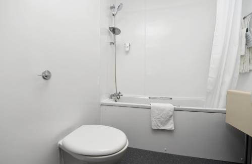 a white bathroom with a toilet and a shower at Wynnstay Arms, Wrexham by Marston's Inns in Wrexham