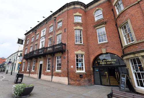 a brick building with a clock on the front of it at Wynnstay Arms, Wrexham by Marston's Inns in Wrexham
