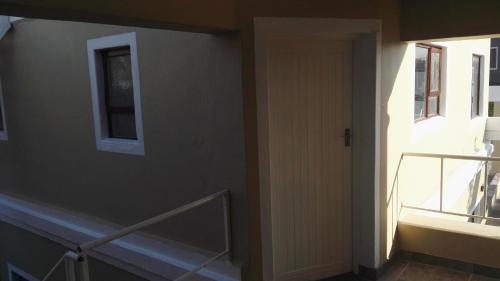 a room with a staircase and a window and a door at Bergsig Selfcatering in Gordonʼs Bay