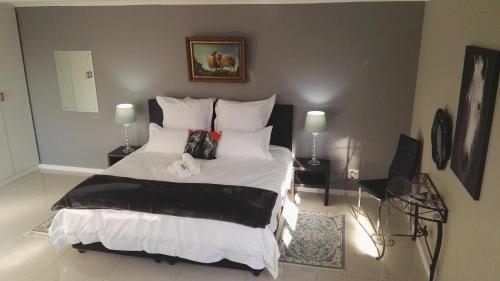 a bedroom with a large bed with white sheets and pillows at Bergsig Selfcatering in Gordonʼs Bay