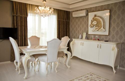 a dining room with a white table and chairs at Grand Atakum Hotel in Samsun