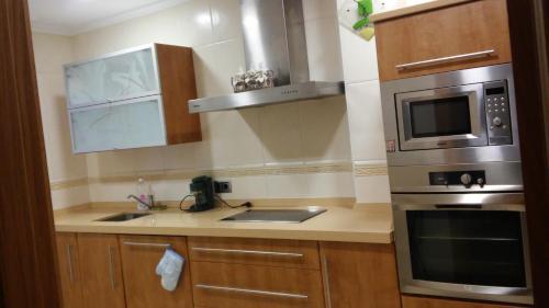 a kitchen with a sink and a microwave at Apartamentos Casa Carmen in Suances