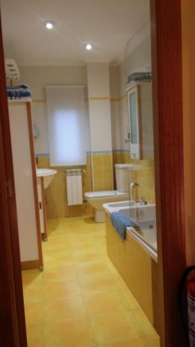a bathroom with a tub and a sink and a toilet at Apartamentos Casa Carmen in Suances