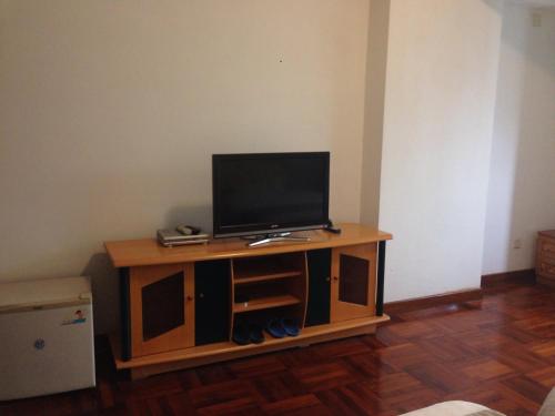 a television on a wooden stand in a room at Huizhan Ge Aparthotel in Shenzhen