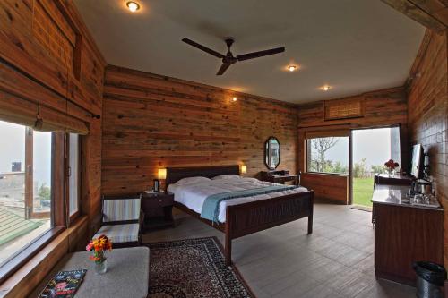 Cedar Lodge By Aahma في Rāmgarh: غرفة نوم بسرير في غرفة بجدران خشبية