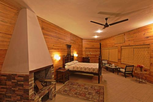 a bedroom with a fireplace and a bed in a room at Cedar Lodge By Aahma in Rāmgarh