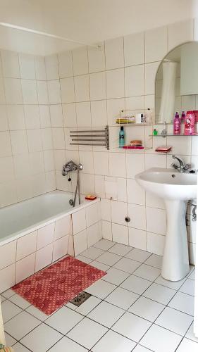 a bathroom with a bath tub and a sink at Jolanda Apartment in Budapest