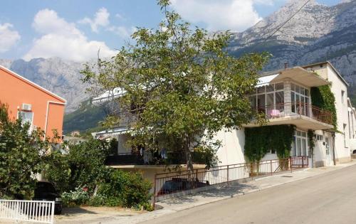 ein Haus auf einer Straße mit Bergen im Hintergrund in der Unterkunft Apartment DAZ in Makarska