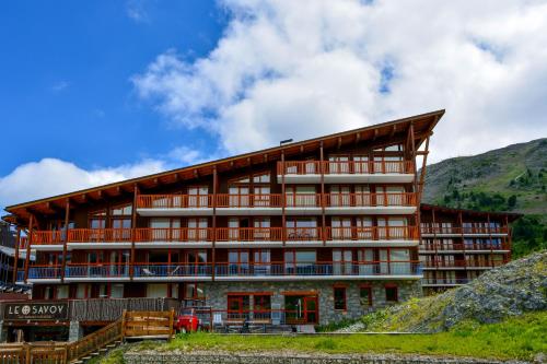 a building on a hill with mountains in the background at Chalet des Neiges : La Cime Des Arcs in Arc 2000
