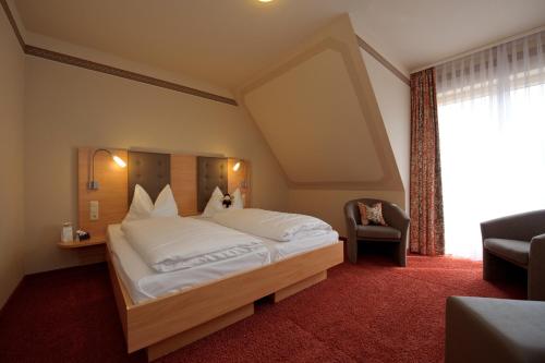 een slaapkamer met een groot wit bed in een kamer bij Land-gut-Hotel Hotel Adlerbräu in Gunzenhausen