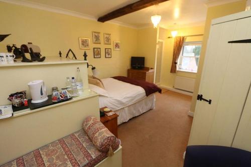a bedroom with a bed and a couch in a room at Ternhill Farm House - 5 Star Guest Accommodation with optional award winning breakfast in Market Drayton