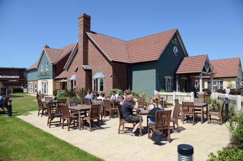 a group of people sitting at tables outside a building at Blue Jay, Derby by Marston's Inns in Derby