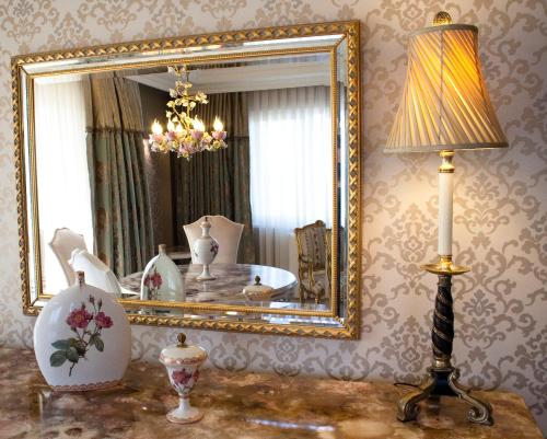 a room with a mirror and a lamp and a table at Grand Atakum Hotel in Samsun