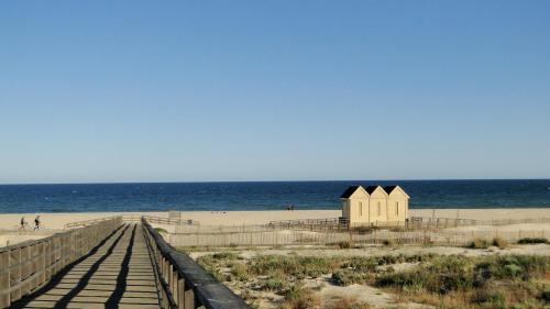 a boardwalk leading to a beach with a small building at Pérola do Oceano in Manta Rota